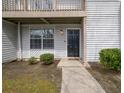 Townhouse entrance with dark front door and manicured landscaping at 7814 Nummie Ct, North Charleston, SC 29418