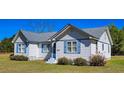 Charming white home featuring a gray roof and blue shutters, set on a well-maintained lawn at 8524 Cane Branch Rd, Ruffin, SC 29475
