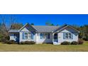 Quaint home with blue shutters and a gray roof, complemented by green landscaping at 8524 Cane Branch Rd, Ruffin, SC 29475