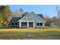 Inviting craftsman-style home with a covered porch, stone pathway, and well-maintained lawn at 10044 Randall Rd, McClellanville, SC 29458