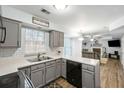 Well-lit kitchen with updated cabinets, stainless steel sink, and a view into the adjacent living room at 102 Kingsbridge Dr, Goose Creek, SC 29445