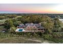 Stunning aerial view of a grand estate with a pool, sprawling grounds, and views of the golf course and adjacent waterway at 108 Salthouse Ln, Kiawah Island, SC 29455