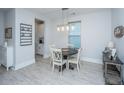 A view of a modern dining area with table and white chairs and decor in a bright, airy space at 1081 Magnolia Warbler Way, Ravenel, SC 29470