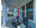 Inviting porch with rocking chairs, decorative accents, and bright siding, offering a relaxing outdoor space at 1081 Magnolia Warbler Way, Ravenel, SC 29470