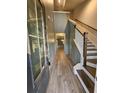 Bright foyer with wood-look floors, staircase with white risers and gray paneled walls at 110 Cypress St, Summerville, SC 29483