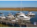 Waterfront marina featuring multiple boats and yachts docked along a wooden pier at 116 Bay Creek Villa, Edisto Beach, SC 29438