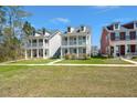 Well-maintained, light-blue, two-story home featuring a covered porch and a lush green lawn at 122 Yorkshire Dr, Moncks Corner, SC 29461