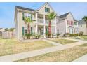 Charming two-story home with a balcony, palm trees and manicured lawn, bathed in sunlight at 125 Old Jackson Rd, Goose Creek, SC 29445