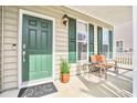 Inviting front porch featuring a cozy bench, stylish lighting, and lush potted plant at 125 Old Jackson Rd, Goose Creek, SC 29445