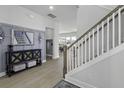 Elegant foyer with stylish console table, mirror, and staircase leading to the upper level with hardwood floors at 181 Ashworth Dr, Summerville, SC 29486