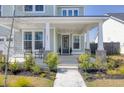 Inviting front porch with classic columns, a cozy seating area, and a beautifully decorated entryway to welcome guests at 181 Ashworth Dr, Summerville, SC 29486