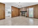 Cozy living room features wood paneling, a brick fireplace, and access to the kitchen at 185 Foxborough Rd, Goose Creek, SC 29445