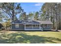 Charming one story home with white picket fence porch and natural landscaping at 212 Lake Moultrie Dr, Bonneau, SC 29431