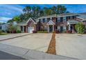 Attractive brick townhouse community featuring individual driveways and lush green trees at 219 Tuscany Ct, Ladson, SC 29456