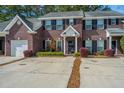 Inviting brick townhouse showcasing a well-maintained front yard and classic black shutters at 219 Tuscany Ct, Ladson, SC 29456