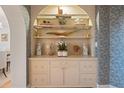 Built-in shelving showcases books, art, and decorative objects against patterned wallpaper at 233 S Plaza Ct # 210, Mount Pleasant, SC 29464