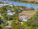 Stunning aerial view of the luxurious waterfront home surrounded by mature trees and a winding driveway at 24 Waterway Island Dr, Isle of Palms, SC 29451