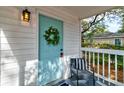 Inviting front porch with a charming blue door, wreath, and a cozy sitting area at 2604 Ferrara Dr, North Charleston, SC 29405