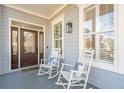 Inviting front porch with rocking chairs, pillows and a stained glass front door at 307 Shoals Dr, Mount Pleasant, SC 29464