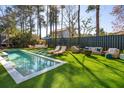 Backyard features a sparkling pool, lounge chairs and green artificial turf at 307 Shoals Dr, Mount Pleasant, SC 29464