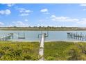 Picturesque dock overlooking tranquil waters with lush greenery in the background under a clear sky at 3121 Marshgate Dr, Johns Island, SC 29455