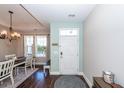 Home entry featuring a white door, hardwood floors, natural light, and adjacent dining area at 327 Freeland Way, Moncks Corner, SC 29461