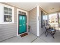 Inviting front porch features a teal front door, neutral siding, and comfortable seating at 327 Freeland Way, Moncks Corner, SC 29461