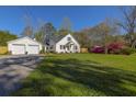 Beautiful home exterior with white siding, a black roof, and lush green lawn with flowering azaleas at 418 Geddes Ave, Charleston, SC 29407