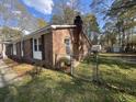 Rear exterior view showing brick detail and a well-maintained, partially-fenced yard at 431 Otis Rd, Walterboro, SC 29488