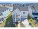 An elevated view of a two-story home with a two-car garage in a neighborhood with a nearby lake at 444 Parish Farm Dr, Summerville, SC 29486