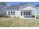 Back view of a house with white siding, a covered patio, and a well-maintained lawn and landscaping at 444 Parish Farm Dr, Summerville, SC 29486