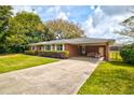 Beautiful red brick home with carport and well-maintained lawn, exudes timeless charm and comfort at 5040 Lancaster St, North Charleston, SC 29405