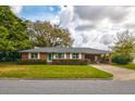 Traditional red brick home with carport, well-kept lawn, and manicured hedges creates an inviting atmosphere at 5040 Lancaster St, North Charleston, SC 29405