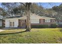 Charming home featuring a well-maintained front lawn, a tree, and a brick and white exterior at 5314 Albert St, North Charleston, SC 29418