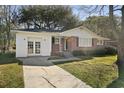 Inviting home with a brick and white exterior, a well-kept lawn, and a welcoming driveway at 5314 Albert St, North Charleston, SC 29418