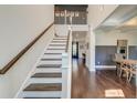 Bright entryway with hardwood floors, white staircase with stained handrail, and views into other living spaces at 5525 Alpine Dr, Summerville, SC 29483