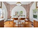 Bright dining area featuring hardwood floors, an arched brick wall, and stylish seating at 56 Parkwood Ave, Charleston, SC 29403