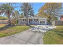Inviting home with painted brick, charming shutters, mature trees, and a paved driveway at 6009 Meadowcliff Ave, Hanahan, SC 29410