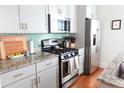Modern kitchen featuring stainless steel appliances, gray cabinets, granite countertops, and a stylish backsplash at 7 Fields Pl, Charleston, SC 29403
