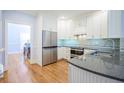 Bright and modern kitchen featuring white cabinets, stainless steel appliances, and hardwood floors at 772 Preservation Pl, Mount Pleasant, SC 29464