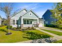 Charming single-story home featuring a welcoming front porch, manicured lawn, and a two-car attached garage at 804 Buckler St, Summerville, SC 29486