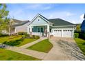 Charming single-story home featuring a welcoming front porch, manicured lawn, and a two-car attached garage at 804 Buckler St, Summerville, SC 29486