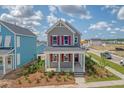 Inviting two-story home with red shutters and a cozy front porch, perfect for enjoying neighborhood views at 820 Gentle Breeze Dr, Summerville, SC 29486