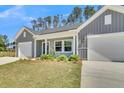 Inviting home exterior featuring a well-manicured lawn, two-car garage, and charming covered porch at 930 Dusk Dr, Summerville, SC 29486