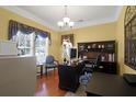 Well-lit home office with a large window, dark wood desk, and built-in shelving at 1067 Shipton Ct, Charleston, SC 29414