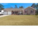 Charming brick home boasts a well-manicured lawn and inviting front porch with rocking chairs at 112 Lois Cir, Moncks Corner, SC 29461