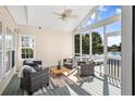 Screened in porch featuring four cushioned chairs surrounding a wooden table, overlooking a beautiful lake at 1124 Clearspring Dr, Charleston, SC 29412