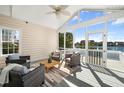 This screened porch boasts comfortable seating and serene lake views, perfect for relaxing outdoors at 1124 Clearspring Dr, Charleston, SC 29412