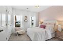Comfortable bedroom featuring white bedding, stylish wallpaper and bright windows at 114 Snow St, Summerville, SC 29486