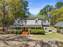 Two-story home with covered front porch, complimented by lush green bushes and an adjacent outbuilding at 1212 Pinopolis Rd, Moncks Corner, SC 29461